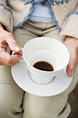 A woman holding a cup of coffee