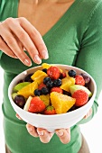 A woman eating fruit salad