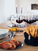 A table laid with appetizers and red wine