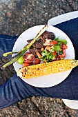 Gegrilltes Rindersteak mit Salat und Maiskolben