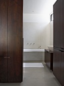 White, designer bathroom with dark wood cupboards