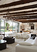 Large, open living room with curved metal wirechandeliers hanging from beamed ceiling made of unworked tree trunks