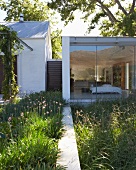 Group of contemporary buildings - view into bedroom through floor-to-ceiling glass wall reflecting mountain landscape