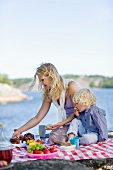 A mother and son having a picnic by a lake