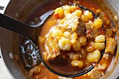 Red Posole; Mexican Hominy Stew; Made with Pork; In Ladle Above Pot