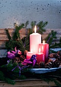 Advent arrangement of candles, pine cones and bird ornaments