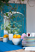 Crockery and flower arrangement on wooden table with blue table runner