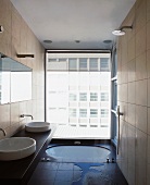 Modern bathroom with floor-level bathtub in front of floor to ceiling window