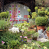 Gemütliche Sitzecke mit roten Klappstühlen und Blumenposter im Garten