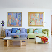 Bright living room with blue and green sofa, painting on the wall