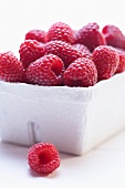 Raspberries in cardboard punnet (close-up)