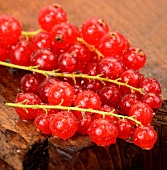 Rote Johannisbeeren auf Holzuntergrund (Nahaufnahme)