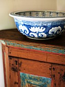 Blue and white ceramic bowl on wooden cabinet