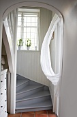 View into wood-clad stairwell with winding staircase