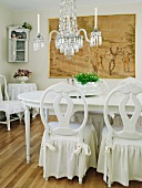 Romantic vintage dining room in white with chandelier and charcoal drawing on wall