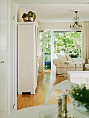 Classic, white, vintage furnishings in living room with view of large windows and balcony door