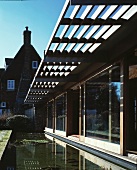 House with sliding glass doors, pergola and water feature