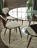 Chairs around glass table with round foot
