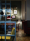 Second-hand chic in London coffee bar with mixture of seating styles between steel frames with glass panels