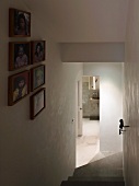 Staircase with collection of framed photographs and view through open bathroom door