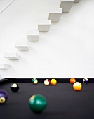 Pool table with floating staircase in background