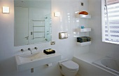 White, modern bathroom with bathtub, toilet & washstand