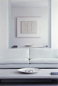 White sofa in front of open doorway to dining room