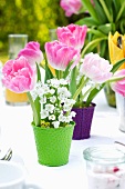 Frühlingsblumendeko mit Tulpen auf gedecktem Tisch