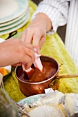 Children's hands dipping marshmallows into chocolate fondue