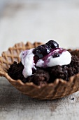 Waffle bowls filled with crumbled brownies, cream and blueberries