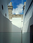 View into courtyard of modern building in front of factory with brick facade