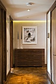 Hallway with modern wood panelling over radiators and old parquet flooring