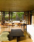 Simple, black coffee table and floor cushions in spacious modern house