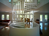 A white spiral staircase in an open-plan living room