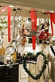 Heart-shaped wreath hanging on hook next to kitchen utensils
