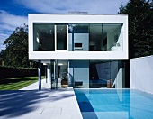 Pool area of two-storey, box-shaped house in glass and concrete