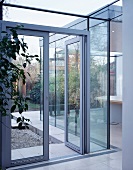 Glastüren und Glaswände trennen den Wohnbereich vom Garten