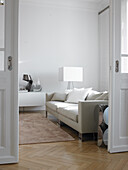 Bright living room with beige sofa and herringbone parquet flooring