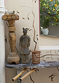 Colonial-style antiques on wooden board against exterior wall