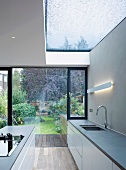 Unterschränke und Kücheninsel in einer Küche mit Glasdach