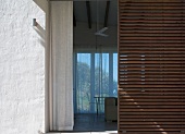 View past slatted wooden door into living room