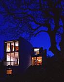 Illuminated house with floor-to-ceiling windows