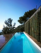 Terrace with swimming pool, closed curtains on one side, sea view on the other