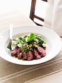 Lamb with spinach and goat's cheese salad and pesto