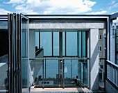 Dachterrasse mit offener Glasfalttür und Blick auf Galerie und in Innenraum