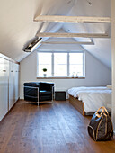 Bedroom with wooden floor and sloping ceiling