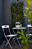 Folding furniture set and plants on vertical garden wall