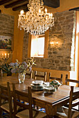 Rustic dining table with crockery and crystal chandelier