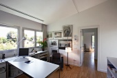 Comfortably arranged office with sloping ceiling and strip parquet flooring