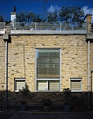 Modernes Wohnhaus mit Ziegelfassade und geschlossenen Jalousien am Fenster